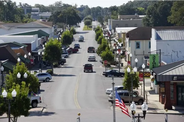Downtown Crestview, Florida looking south along Main Street with brick storefronts and street lamps.