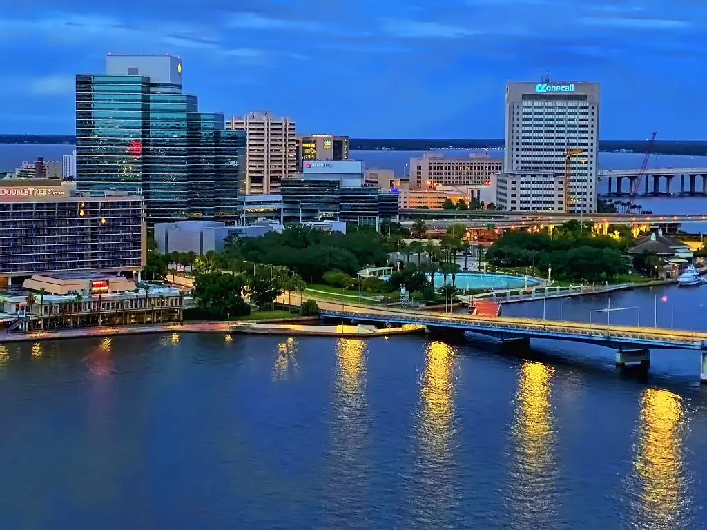 Downtown Jacksonville skyline in Duval County, Florida at blue hour with the St. Johns River and Main Street Bridge lights.
