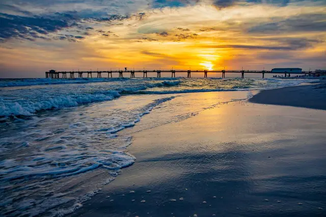 Golden sunset over the fishing pier and surf near Shalimar, Florida.