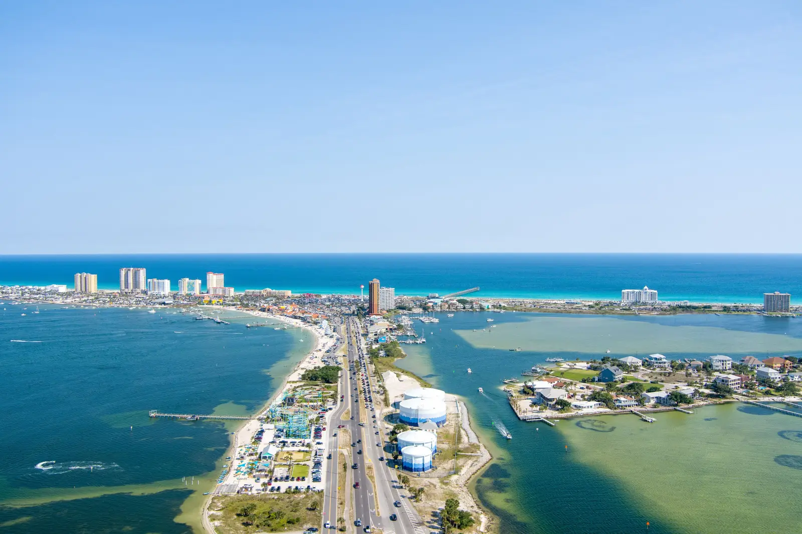 Aerial view of Gulf Breeze, Florida with the causeway, bay waters, and Pensacola Beach skyline beyond.